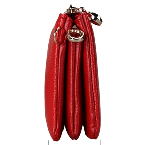 Close-up of red pebbled leather shoulder bag showing three-layer accordion structure and gold zipper