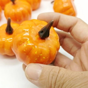 Macro shot of 5cm mini artificial orange pumpkin with realistic texture for DIY crafts