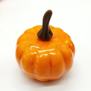 Macro shot of a 5cm glossy orange artificial foam pumpkin with realistic texture