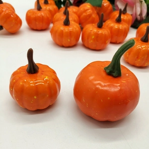 Macro close-up of decorative artificial mini pumpkins in bright orange for festive decor