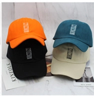 Detail showing various colors of whale pattern bucket hats on white marble surface