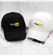 Detail of black and white cotton baseball caps with embroidered logo on marble background