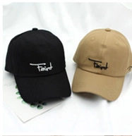 Detail view of cotton baseball caps in black and khaki with Faint letter embroidery