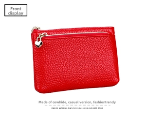 Detail view of red lychee grain leather coin purse with heart shaped gold zipper charm