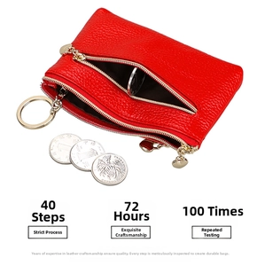 Macro shot of red pebble grain leather coin purse with heart-shaped zipper and gold keyring