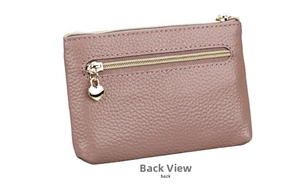 Detail view of pink pebbled leather coin purse featuring double zippers and heart charm