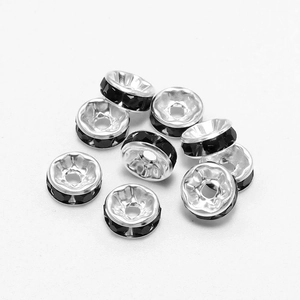 Macro shot of silver metal rondelle spacer beads with faceted black rhinestones