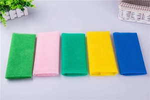 Flat lay of five colorful nylon exfoliating bath towels in green pink yellow and blue