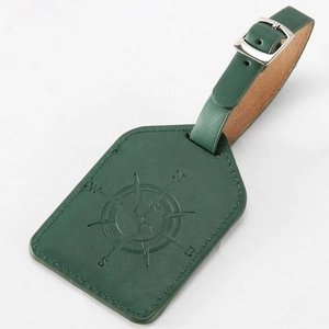 Detail of green PU leather luggage tag featuring embossed compass design and metal buckle