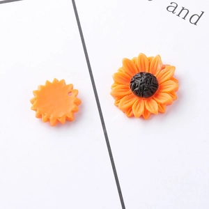 Macro detail of sunflower resin charms showing front petal texture and flat back structure