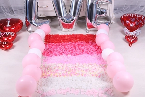Romantic wedding room setup with red petals and silver LOVE foil balloons for proposals