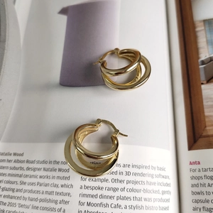 Macro shot of 925 sterling silver triple-hoop earrings with S925 stamp on a magazine