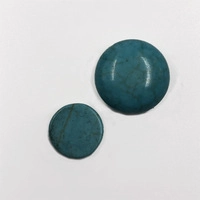 Top view of two round turquoise natural stone beads with smooth texture on white background