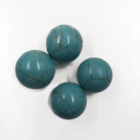 Macro shot of four turquoise stone beads with natural black veins on white background