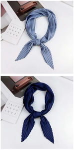 Detail of pleated rhombic scarves in light blue grey and navy with elegant accordion folds