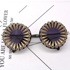 Retro round sunglasses with sparkling rhinestones and golden sunburst spikes on white card