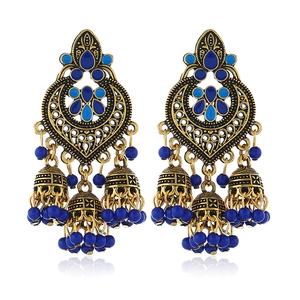 Detail of bohemian tassel earrings with blue beads and antique gold finish