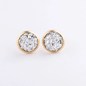 Macro detail of 10mm round gold-plated stud earrings featuring sparkling silver mineral crust
