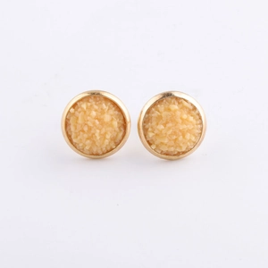 Macro detail of 10mm round gold-plated stud earrings with beige mineral druzy texture
