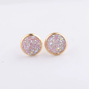 Close-up of 10mm round gold earrings with pink sparkling resin crystal druzy texture