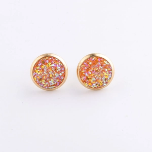 Close-up of 10mm round gold plated stainless steel studs with sparkling orange glitter