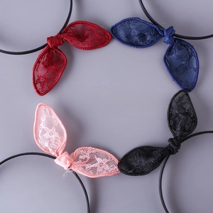 Detail of four handmade lace bow hair ties in red, blue, pink, and black colors