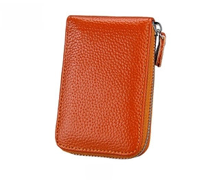 Detail of orange pebble grain leather wallet showing silver zipper and stitching