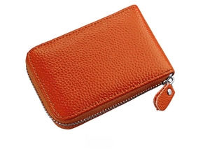 Side view of orange pebbled leather card holder with silver zipper and neat stitching