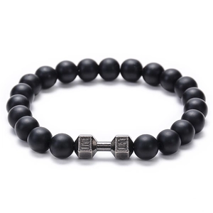 Detail of matte black beads bracelet with gunmetal dumbbell charm and engraved text
