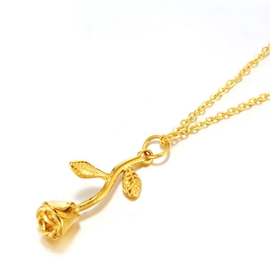 Detailed view of a golden rose pendant necklace with engraved bud and leaf on a fine chain