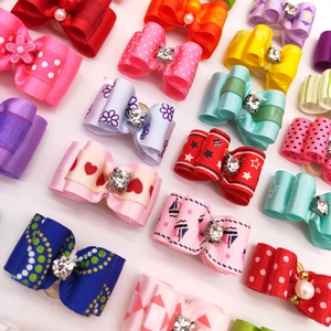 Detailed grid of colorful pet hair bows with rhinestones in various patterns and styles