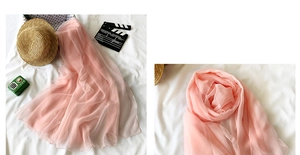 Close-up of pink chiffon beach scarf texture with summer travel accessories