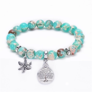 Macro view of blue emperor stone beads with tree of life and flower silver pendants