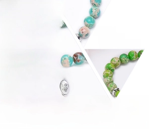 Macro detail of turquoise natural stone beads with silver tree of life and flower charms
