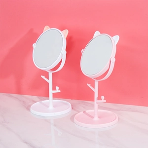 Detail of pink and white cat-ear desktop vanity mirrors with jewelry storage base