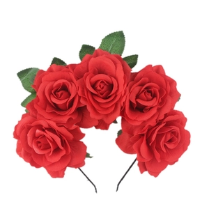 Close-up of red rose floral headband with five fabric roses and green leaves for dancing