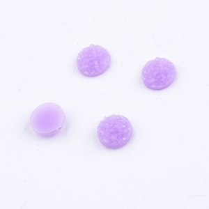 Detailed view of four 8mm round purple resin cabochons with sparkling glitter finish