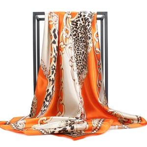 Detail of silk-satin scarf with leopard and chain print on elegant black metal frame