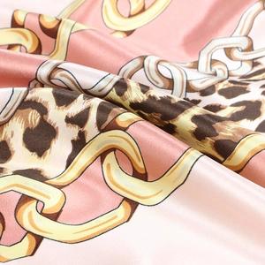 Detail of pink satin scarf with gold chain and leopard print showing smooth fabric texture