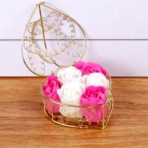 Detail of pink and white soap roses in a heart-shaped golden wire basket decor