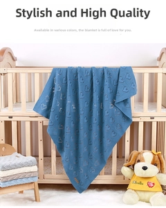 Close-up of knit baby blanket with heart hollow patterns in light blue, grey and beige