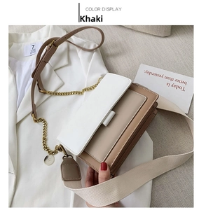 Khaki crossbody bag detail with metal chain and wide canvas strap on white suit