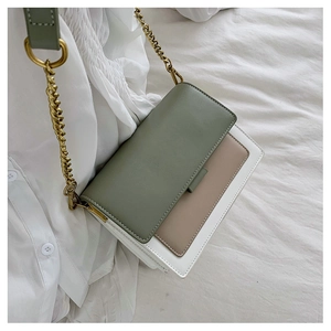 Detail of color-block flap bag in green and beige with vintage bronze chain strap