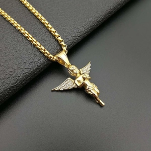 Gold plated angel wing pendant necklace with cubic zirconia on black leather surface