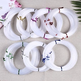 Flat lay of multiple white elastic crystal string rolls for DIY jewelry and beadwork
