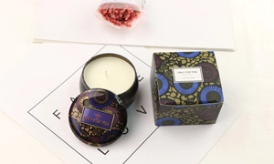 Detail of aromatic soy candle in vintage floral tin with matching gift box on decorative card