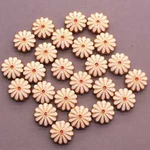 Detailed macro of daisy-shaped alloy beads with white petals and golden enamel trim