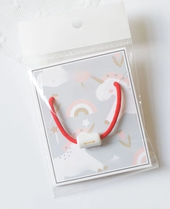 Close-up of Libra constellation red woven bracelet in printed OPP packaging bag