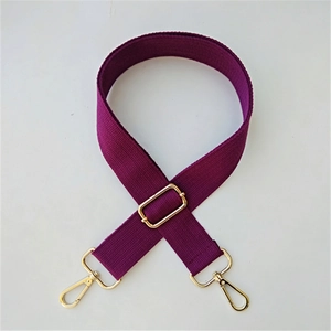 Macro detail of high-quality adjustable purple nylon bag strap with premium gold hardware