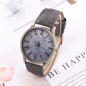 Macro detail of bronze quartz watch featuring grey denim texture and Roman numerals